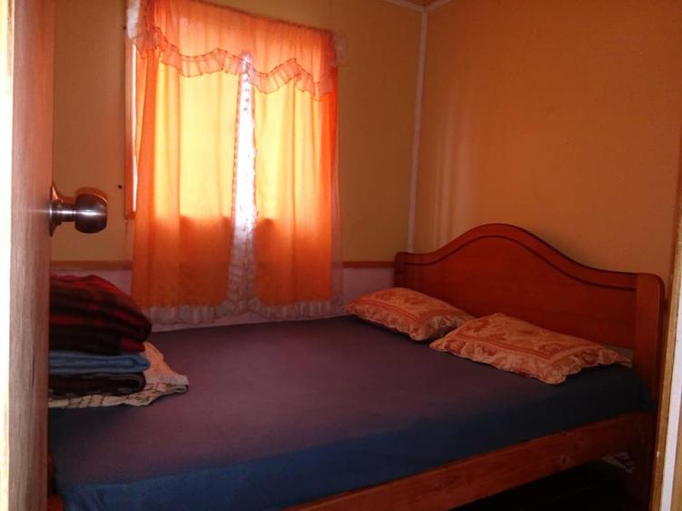 Dormitorio de cabaña con cama de madera