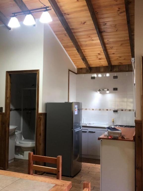 Cocina con refrigerador y comedor bajo techo de madera